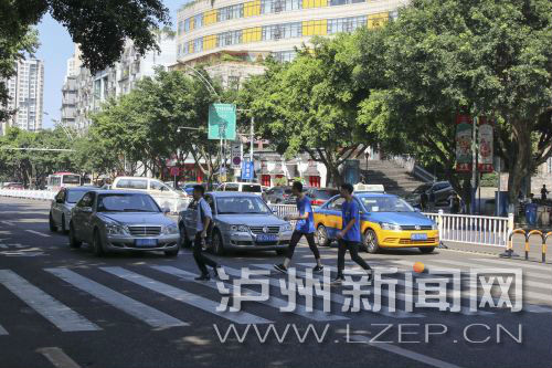 四川警察學(xué)院前的斑馬線沒有紅綠燈，但過往車輛見到有行人過斑馬線都會禮讓行人